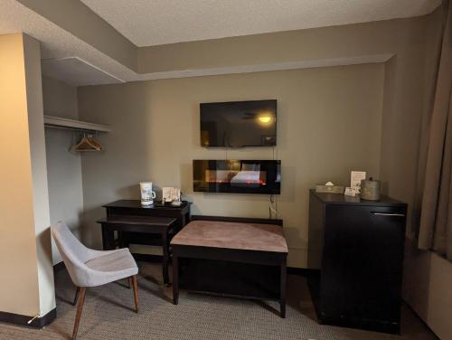 a hotel room with a table and a desk and a tv at King Edward Hotel in Banff