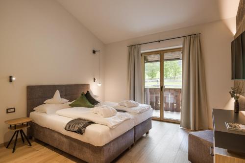 a bedroom with a large bed and a large window at Hotel Oberwirt in Verano
