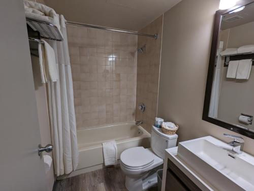 a bathroom with a toilet and a tub and a sink at King Edward Hotel in Banff