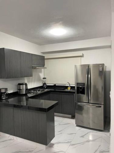 a kitchen with a stainless steel refrigerator and cabinets at Costa Malaga 1 Banus in Acapulco