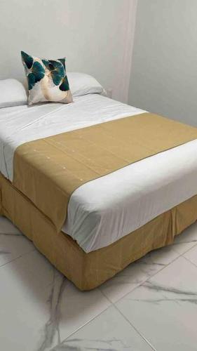 a bed with a brown blanket and a pillow on it at Costa Malaga 1 Banus in Acapulco
