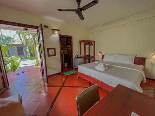 1 dormitorio con 1 cama, mesa y sillas en Natural Relax Villa, en Siem Reap