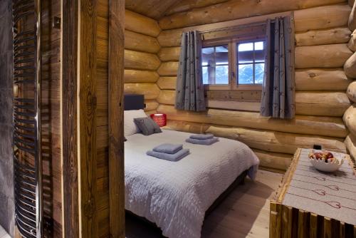 a bedroom with a bed in a log cabin at Chalet Nanook, charme et luxe Pyrénéen in Bolquere Pyrenees 2000