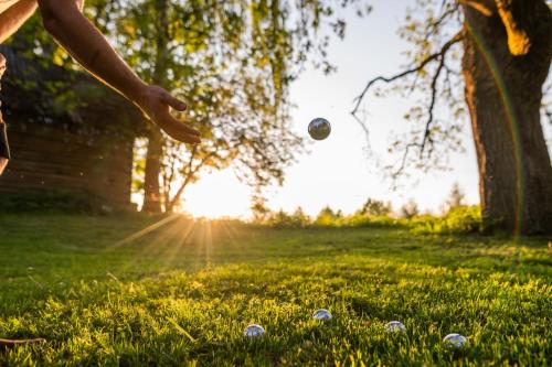 a person throwing a ball in the grass at TaaliHomes Vanaküla Puhkemaja - Saun ja kümblustünn hinnas in Vanaküla