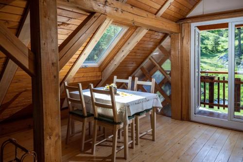 ein Esszimmer mit einem Tisch und Stühlen in einer Hütte in der Unterkunft Apiary at Klemen's in Črni Vrh