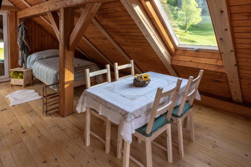 ein Esszimmer mit einem Tisch und Stühlen in einer Hütte in der Unterkunft Apiary at Klemen's in Črni Vrh