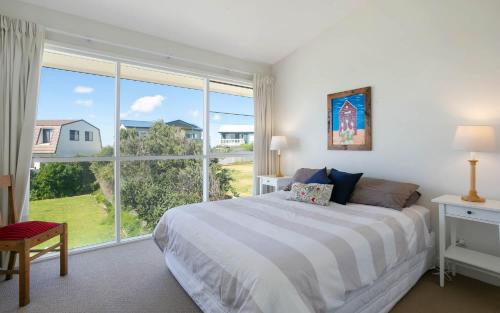 a bedroom with a bed and a large window at 124 Surfers Pde - BYO Linen Beachfront in Middleton