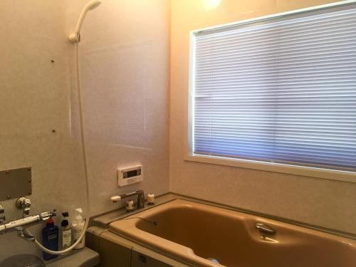 a bathroom with a bath tub and a window at Hatake no Oyado - Vacation STAY 74494v in Takeda