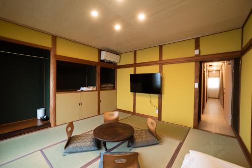 a room with a table and chairs and a television at 三津ミーツ in Mitsuhama