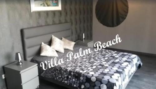 une chambre avec un lit avec un panneau dessus dans l'établissement Villa Palm Beach - Cap d'agde - 450m Plage, au Cap d'Agde