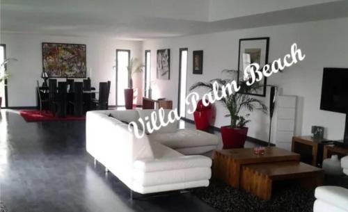 - un salon avec un canapé blanc et un panneau dans l'établissement Villa Palm Beach - Cap d'agde - 450m Plage, au Cap d'Agde