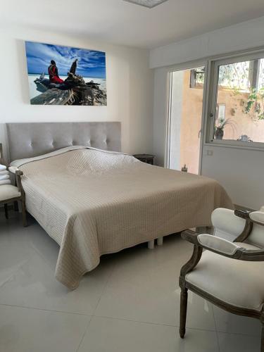une chambre avec un grand lit et une fenêtre dans l'établissement Villa Soley, à Cannes