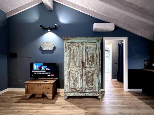 an old wooden door in a room with a tv at La Via di Leonardo in Sesto Calende