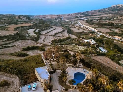 an aerial view of a villa with a swimming pool at Luxury Farmhouse Villa surrounded with Nature & Farm Animals Alpacas etc in Għasri