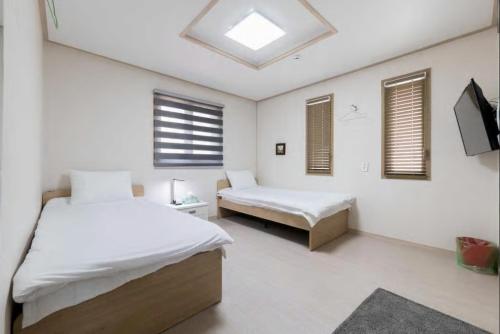 a bedroom with two beds and a skylight at Hub Guest House in Incheon