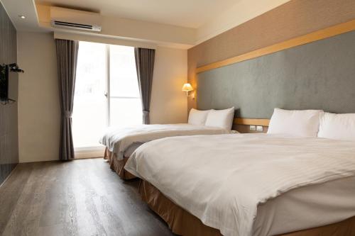 F Hotel Jian في جيان: غرفة فندقية بسريرين ونافذة