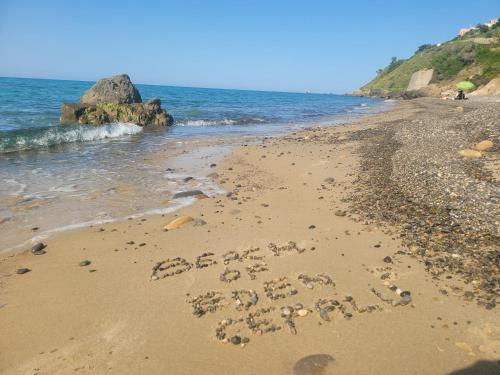 a message written in the sand on a beach at Beach of Eden Cefalu' in Cefalù