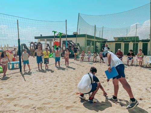 a group of people playing volley ball on a beach at Brora Family Village in Lido di Savio