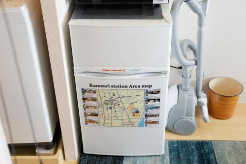 a white water heater in a room with a vacuum at Kameari 1108 Budget Stay High Floor Near Station Mall Disney Access in Tokyo