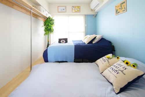 two beds in a room with blue walls at Kameari 1108 Budget Stay High Floor Near Station Mall Disney Access in Tokyo