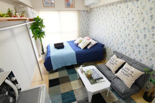 東京的住宿－SC Kameari 1103，一个小客厅,配有一张床和一张沙发