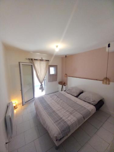 ein Schlafzimmer mit einem großen Bett und einem Fenster in der Unterkunft Le cosy in Clermont-lʼHérault