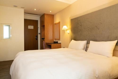 a large white bed in a hotel room at 沐棧行旅-花蓮Muchan Hotel-Hualien in Jian