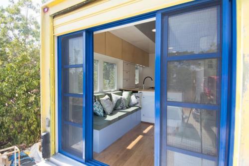 a house with a blue door and a couch in a kitchen at המשאית הצהובה in Yavneʼel
