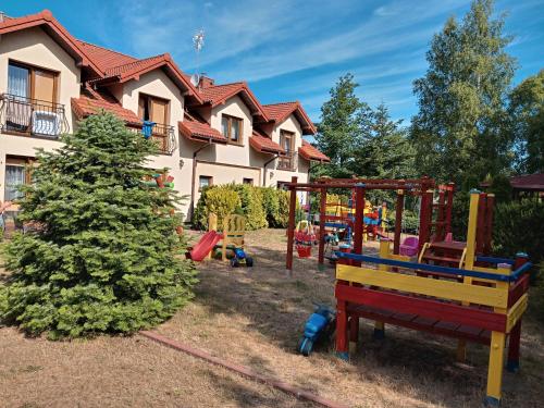 a yard with a playground in front of a house at Villa Majorka in Rowy