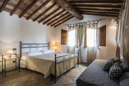 a bedroom with a bed and a couch at Villa Loghino in Volterra