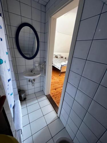 baño con espejo y lavabo en Szőlőskert Studio Apartman Ábrahámhegy en Ábrahámhegy