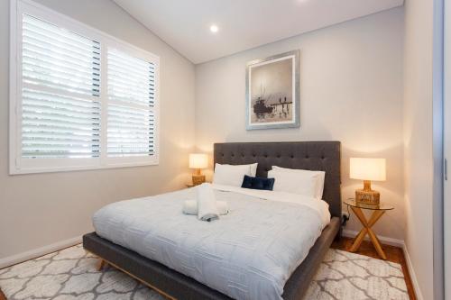 a bedroom with a large bed with two lamps at Luxury Modern Escapia in Fremantle