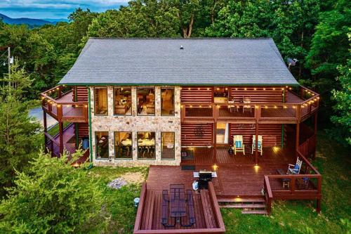 an aerial view of a log home with a deck at Panorama Mountain View Cabin, Less than 10 miles from Gatlinburg and Dollywood, Dog Friendly, 6 Bedrooms Sleeps 17, Fire Pit, HotTub, Washer Dryer, Fully loaded Kitchen, GameRoom with a TV, Pool Table, Arcade, Air Hockey, and Foosball in Sevierville