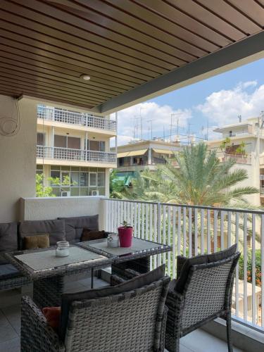 d'une terrasse avec une table et des chaises sur un balcon. dans l'établissement Lovely Faliro Apartment next to the sea., à Athènes