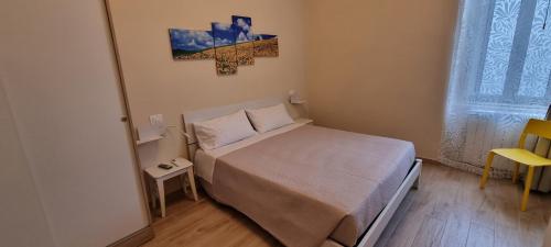 ein kleines Schlafzimmer mit einem Bett und einem Kreuz an der Wand in der Unterkunft Happy b&b in Torre Maggiore