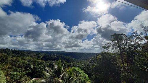 uma vista para uma floresta com nuvens no céu em Bon Mange Organic Farm em Vieux Fort