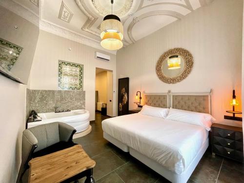 バダホスにあるAkla Hotel Badajozのベッドと浴槽と洗面台のある寝室