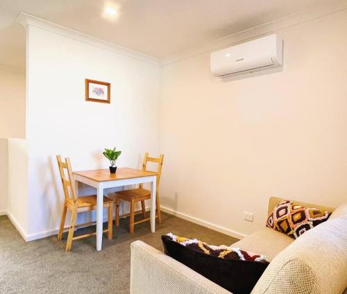 a living room with a table and a couch at Casey Green Townhouse by GoodLive in Narre Warren