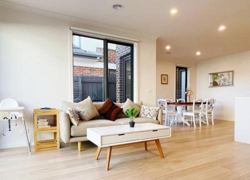 a living room with a couch and a table at Casey Green Townhouse by GoodLive in Narre Warren