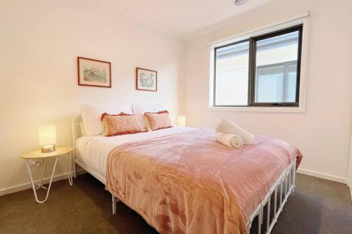 a bedroom with a large bed and a window at Casey Green Townhouse by GoodLive in Narre Warren