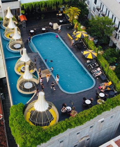 an overhead view of a swimming pool with people sitting around it at The Twizt - Lifestyle Hostel & Hotel in Siem Reap
