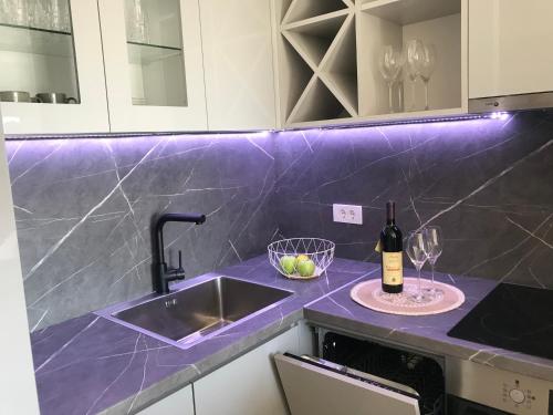 a kitchen counter with a sink and a bottle of wine at Cosy studio apartment in Budva with sea view in Budva