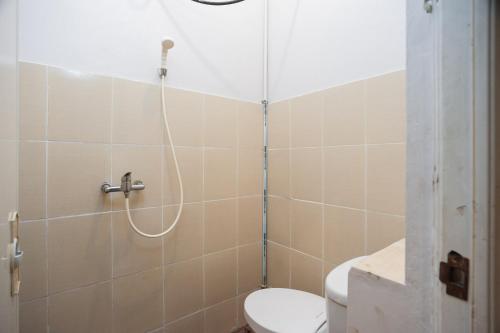 y baño con ducha, aseo y lavamanos. en RedDoorz Syariah near Taman Air Mancur Bogor en Bogor