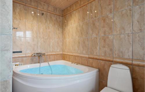 a bathroom with a tub with water in it at Awesome Home In Skjern With Wifi in Halby