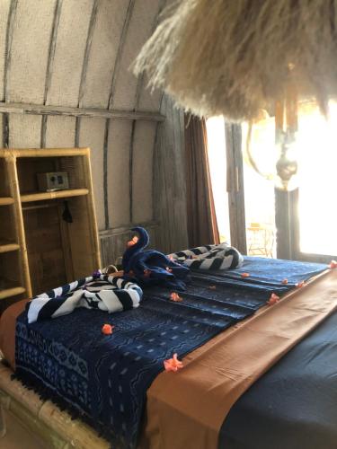 um quarto com um pássaro sentado em cima de uma cama em La Bohème em Gili Air