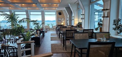a restaurant with tables and chairs and a view of the ocean at Hotel Lysekil in Lysekil