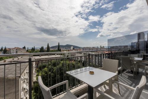 a balcony with a white table and chairs at Art Hotel in Split