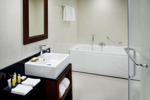 La salle de bains est pourvue d'un lavabo et d'une baignoire. dans l'établissement Marriott Executive Apartments Addis Ababa, à Addis-Abeba