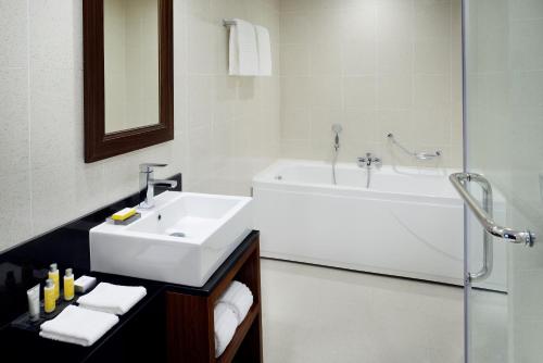 een badkamer met een wastafel, een bad en een wastafel bij Marriott Executive Apartments Addis Ababa in Addis Ababa