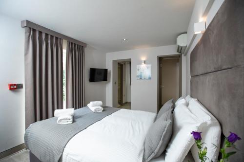 a bedroom with a white bed with towels on it at Arch Hotel in London